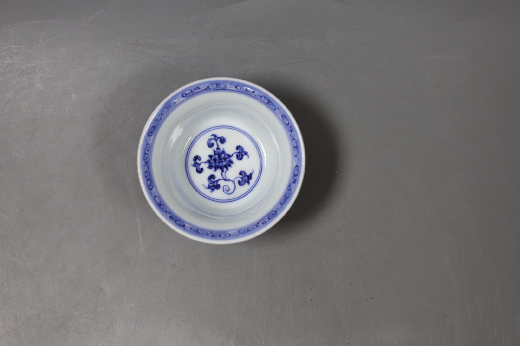 A Chinese blue and white bowl with floral motif, inscription to base - 4cm tall